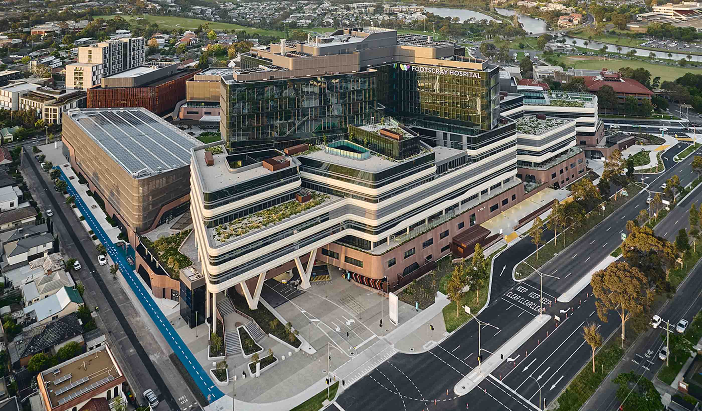 Rendering of a path with people walking leading up to the new hospital building